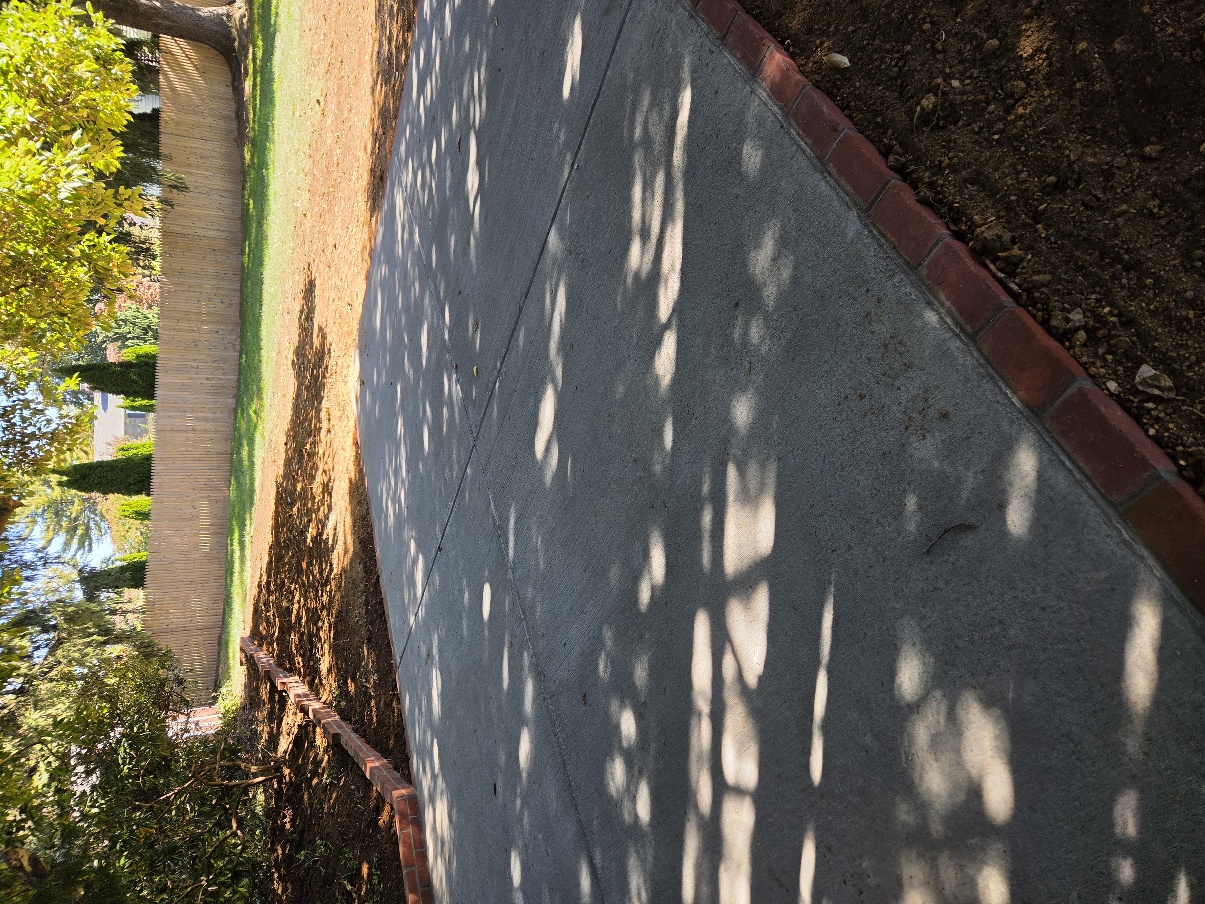 Finished backyard concrete patio with brick edging in Paoli PA
